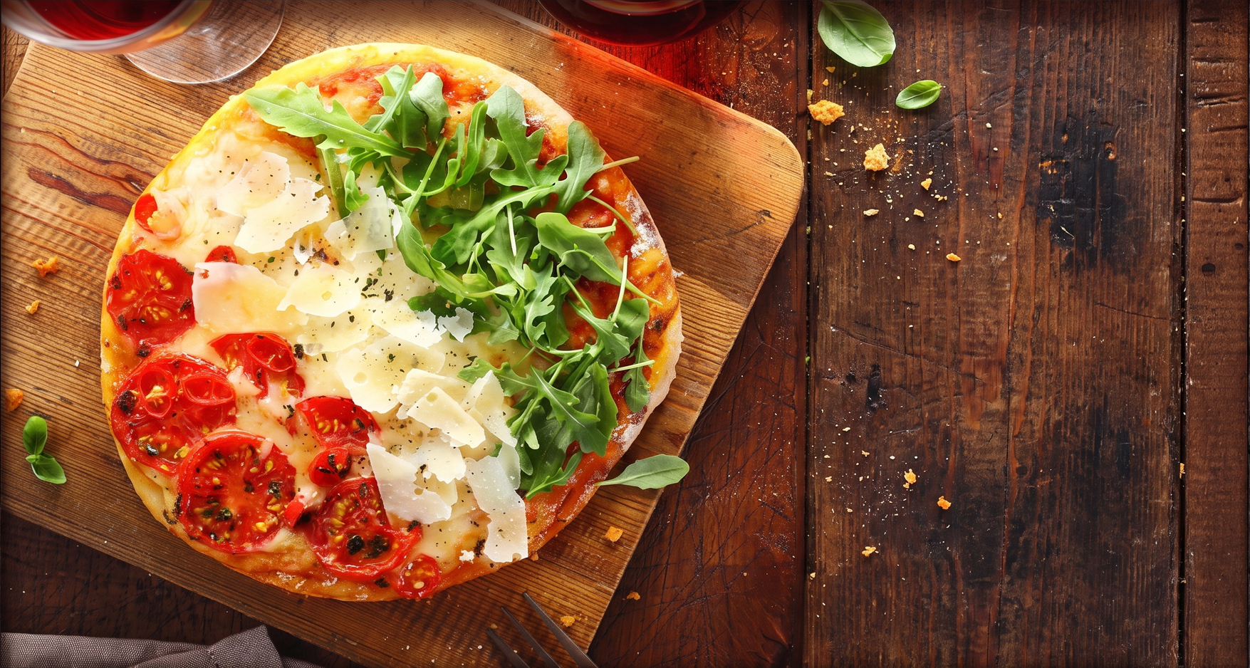 Pizza topped with tomato, parmesan and rocket