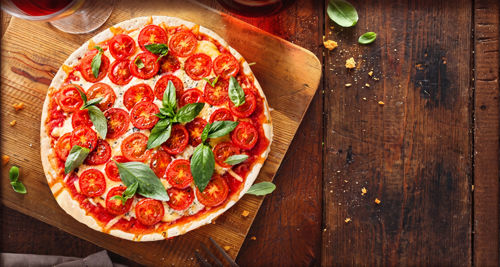 Tomato and basil pizza on a wooden board